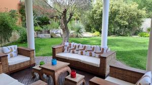 weranda z dwoma kanapami i stołem w obiekcie VILLA PALMIER avec PISCINE CHAUFFÉE PRIVÉE proche D'UZES ET ANDUZE w mieście Cannes-et-Clairan