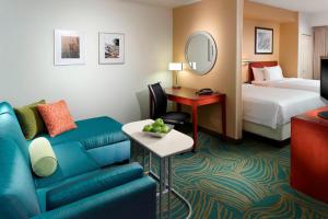 SpringHill Suites by Marriott Atlanta Buckhead في أتلانتا: غرفة في الفندق مع أريكة وسرير