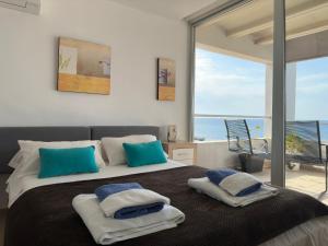 1 dormitorio con 1 cama grande con almohadas azules y blancas en Calatabarca B&B, en Tabarca