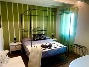 un dormitorio con una cama negra con dosel y zapatos. en Star Soave Rooms - Locazione Turistica, en Soave