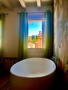 y baño con bañera y ventana. en Star Soave Rooms - Locazione Turistica, en Soave