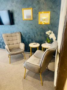 フルダにあるホテル アム シュロスの椅子2脚、テーブル1台、鏡1台が備わる客室です。