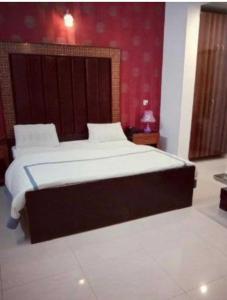ein großes Bett in einem Schlafzimmer mit einer roten Wand in der Unterkunft OYO Home Safe In in Rohtak