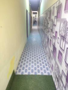 a hallway with a tile floor and paintings on the wall at OYO Home Safe In in Rohtak