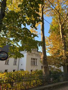 a building with a hotel sign in front of a tree at Főnix Hotel in Balatonföldvár