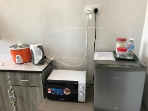 eine kleine Küche mit einer Mikrowelle und einem Toaster in der Unterkunft An-Nur Homestay in Sungai Petani