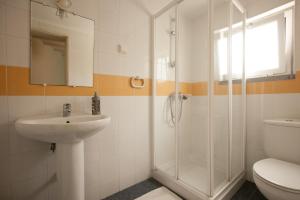 a bathroom with a shower and a sink and a toilet at Ericeira Surf Camp in Ericeira