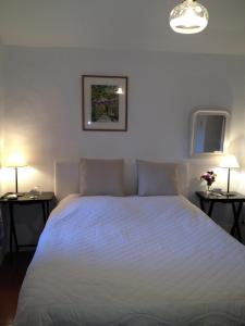 ヴェゾン・ラ・ロメーヌにあるGîte Petite Maison Le Jardinのベッドルーム1室(白いベッド1台、ランプ2つ付)
