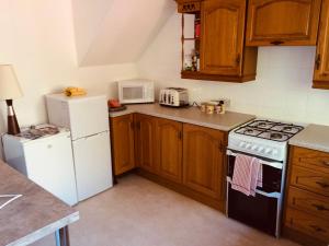 a kitchen with wooden cabinets and a white refrigerator at Invermac House in Inverness