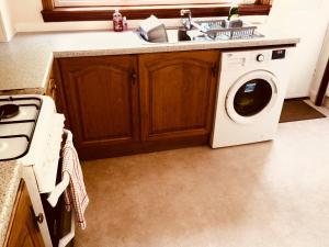 a kitchen with a washing machine and a sink at Invermac House in Inverness