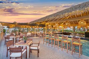a restaurant with tables and chairs and a bar at Liberty Hotels Lara in Lara