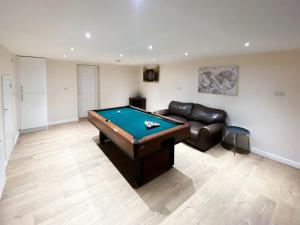 a living room with a pool table and a leather couch at Filey Central Two - Uk42903 in Filey