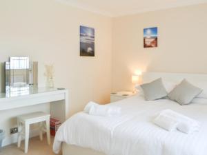 a white bedroom with a bed and a mirror at Filey Central Two - Uk42903 in Filey