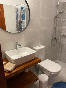 a bathroom with a sink and a toilet and a mirror at Fedra Apartments Lindos in Líndos