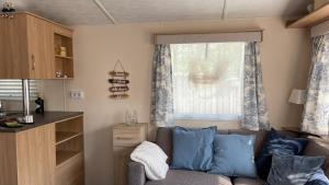 a living room with a couch and a window at PURE - Chalet Zeeland - own washing machine and dryer in Hoek