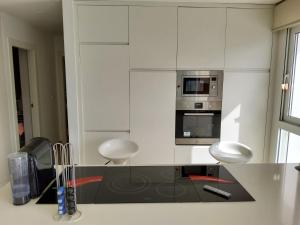 a kitchen with white cabinets and a black counter top at Villa Marjal in Guardamar del Segura +24 photos