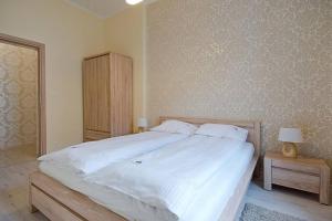 um quarto com uma grande cama branca com duas mesas de cabeceira em Bryza - apartament w Sopocie by Grand Apartments em Sopot