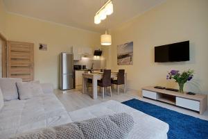 uma sala de estar com um sofá branco e uma mesa em Bryza - apartament w Sopocie by Grand Apartments em Sopot