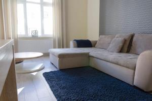 uma sala de estar com um sofá e um tapete azul em Bryza - apartament w Sopocie by Grand Apartments em Sopot