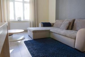 a living room with a couch and a blue rug at Bryza - apartament w Sopocie by Grand Apartments in Sopot