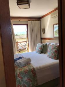 Dormitorio pequeño con cama y ventana en Bangalô em Ilhabela/Yacamim, en Ilhabela