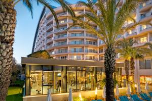 a hotel with palm trees in front of it at Liberty Hotels Lara in Lara