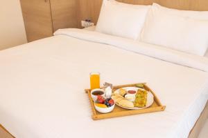 a tray of food and drinks on a bed at Pushp Vatika Resort & Lawns in Navi Mumbai
