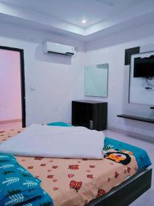 Kurukshetra的住宿－POP Hotel H5，一间卧室配有一张床和一台平面电视