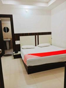 Kurukshetra的住宿－POP Hotel H5，一间卧室配有一张带红色毯子的床