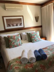 a bedroom with a large bed with towels on it at Bangalô em Ilhabela/Yacamim in Ilhabela