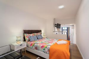 1 dormitorio con 1 cama y 1 silla en Apartamento Qian porto Centro, en Oporto