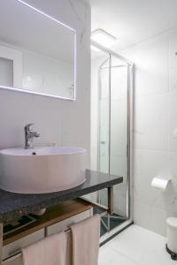 Baño blanco con lavabo y espejo en Apartamento Qian porto Centro, en Oporto