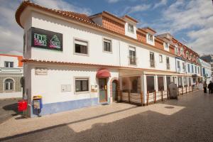 a white building with a sign on the side of it at Ericeira Surf Camp in Ericeira