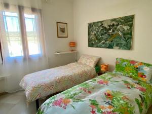 una camera da letto con un letto e un dipinto sul muro di Stintino casa panoramica a 500 mt dal mare IUN E8597 a Stintino