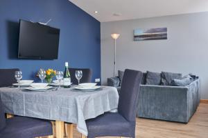 a dining room with a table and a couch at Family Friendly, self contained, Bed and Breakfast with private hot tub in Laugharne