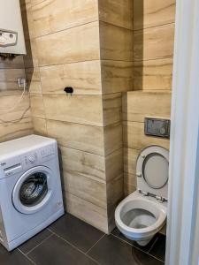a bathroom with a toilet and a washing machine at Modern Apartment in Września