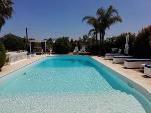 a swimming pool with blue water in a yard at Sole&Mare in Monopoli