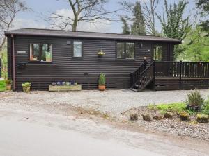 a black tiny house with a porch and a staircase at Derwent Lodge in Keswick