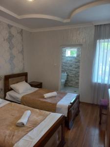 a hotel room with two beds and a window at Guest House IRAKLI in P'ari