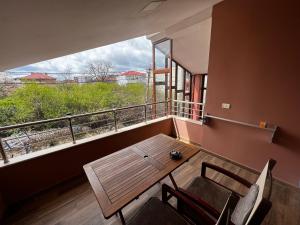 d'un balcon avec une table, des chaises et une fenêtre. dans l'établissement Lovely and cozy 1-bedroom house with a sunny patio, à Korçë