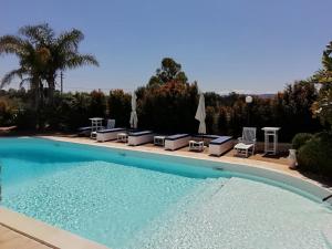 a large swimming pool with chairs and umbrellas at Sole&Mare in Monopoli