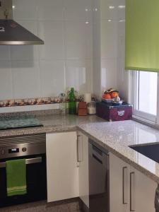 eine Küche mit einem Herd und einer Arbeitsplatte in der Unterkunft Apartamento luminoso con jardín in La Zubia