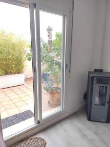 una puerta corredera de cristal que da a un patio con TV en Apartamento luminoso con jardín en La Zubia
