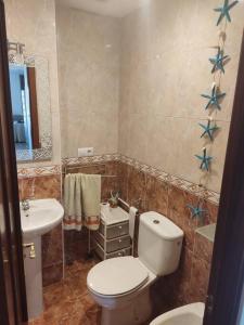 ein Bad mit einem WC und einem Waschbecken in der Unterkunft Apartamento luminoso con jardín in La Zubia