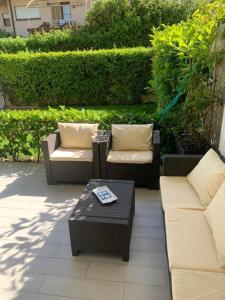 un patio con 2 sofás y una mesa de centro y sidx sidx sidx sidx en Casa Levante Fregene, mare e relax vicino Roma, en Fregene