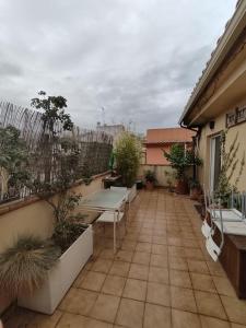 eine Terrasse mit Tischen und Bänken auf einem Gebäude in der Unterkunft Apartamento luminoso con jardín in La Zubia