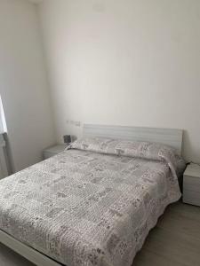 Un dormitorio con una cama con una manta. en Casa Levante Fregene, mare e relax vicino Roma, en Fregene