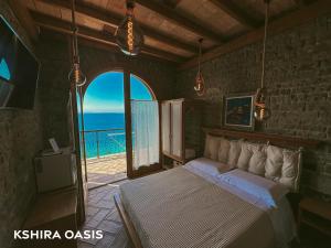 een slaapkamer met een bed en uitzicht op de oceaan bij Kshira Oasis - Luxury 7-Bedroom Vila in Qeparo