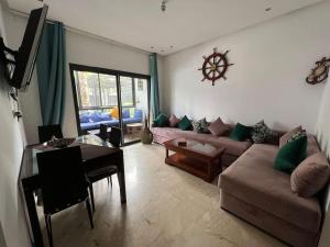 BM Resort في الدار البيضاء: غرفة معيشة مع أريكة وطاولة