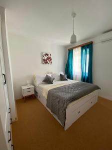 Schlafzimmer mit einem Bett und einem Fenster mit blauen Vorhängen in der Unterkunft Stone House Grgurevic in Rogoznica
